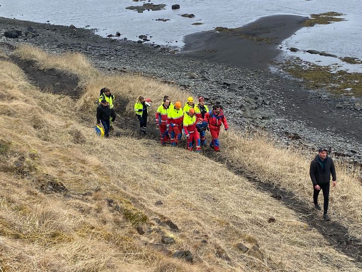 Björgunarfólk bar ferðamanninn á börum eftir fjörunni þar sem of erfitt var talið að koma honum aftur upp brekkuna þar sem hann féll. 