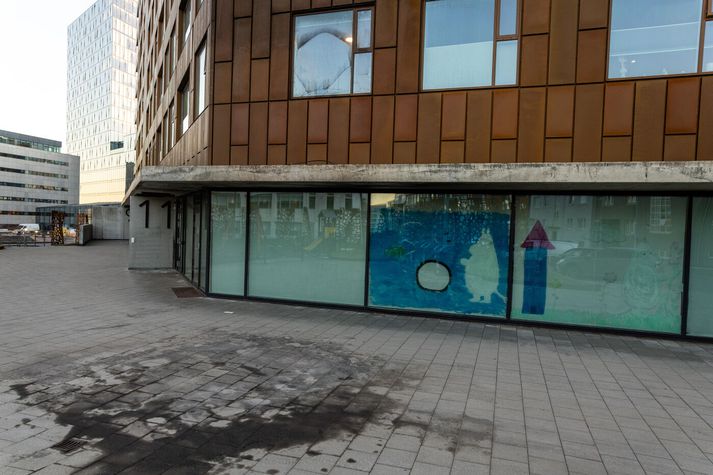 Eins og sést er rúðan brotin og húsið þakið sóti. Þá sést einnig sót á gangstéttarhellunum fyrir utan.