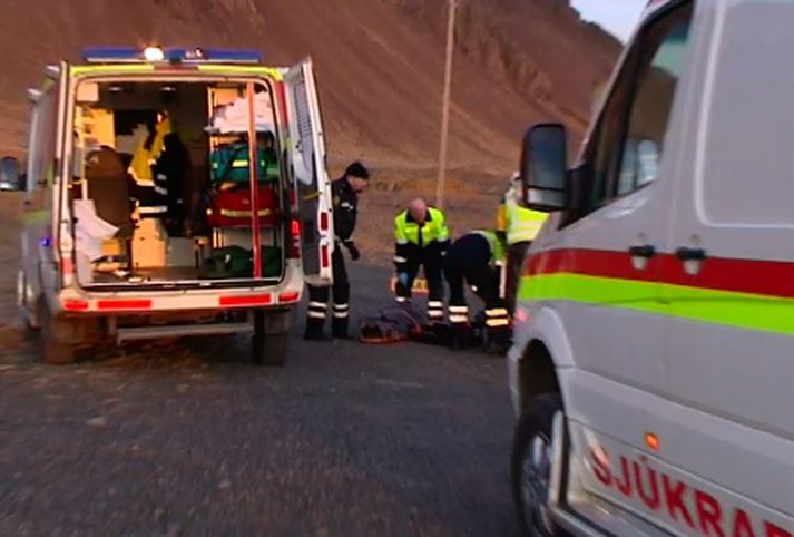 Sjúkramenn hlúa að slösuðum fjórhjólamanni.