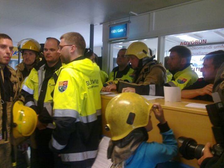 Slökkviliðsmenn standa fyrir útgönguleiðum.