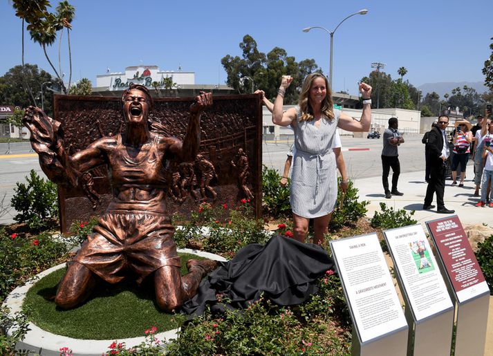 Brandi Chastain við hliðina á nýju styttunni.