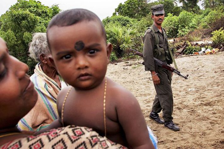 Móðir, barn og hermaður Um fimmtíu þúsund óbreyttir borgarar eru sagðir í sjálfheldu á milli tamiltígra og stjórnarhersins á Srí Lanka.  
Mynd/GettyImages