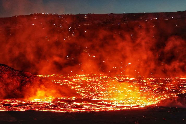 Þessi mynd er tekin á gosstöðvunum í gærkvöldi en á henni má sjá glitta í höfuðljós fjölda þeirra sem lögðu leið sína á svæðið.