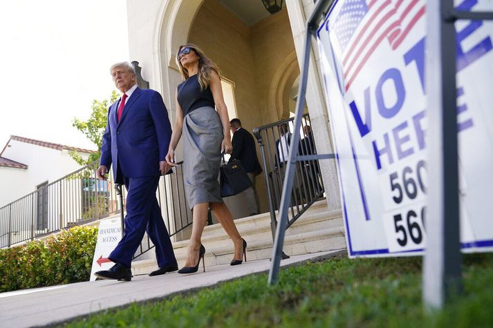 Donald Trump og Melania eiginkona hans ganga út af kjörstað í Florida í gær. 