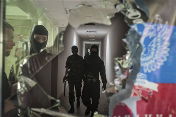 Grímuklæddir aðgerðarsinnar láta til sín taka í Mariupol í Úkraínu á laugardaginn.