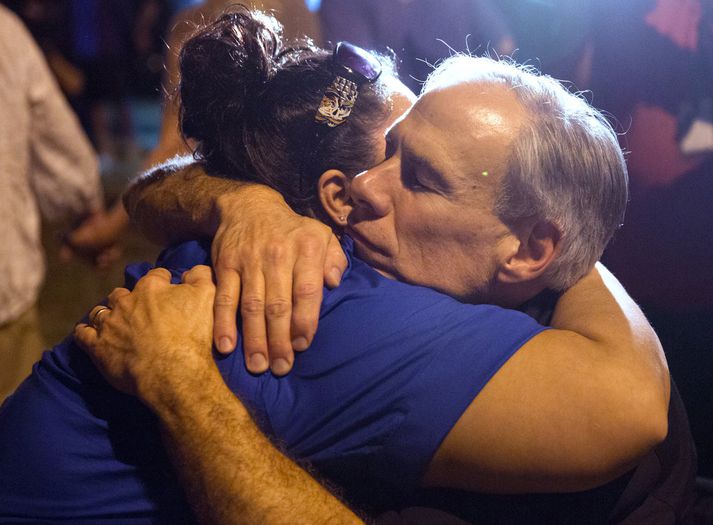 Greg Abbott, ríkisstjóri í Texas, faðmar íbúa eftir skotárásina á kirkju í Sutherland Springs.