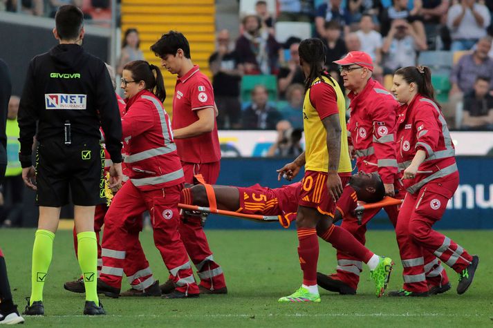 Evan Ndicka sést sér borinn af velli eftir að hann hneig niður í leik Roma og Udinese.