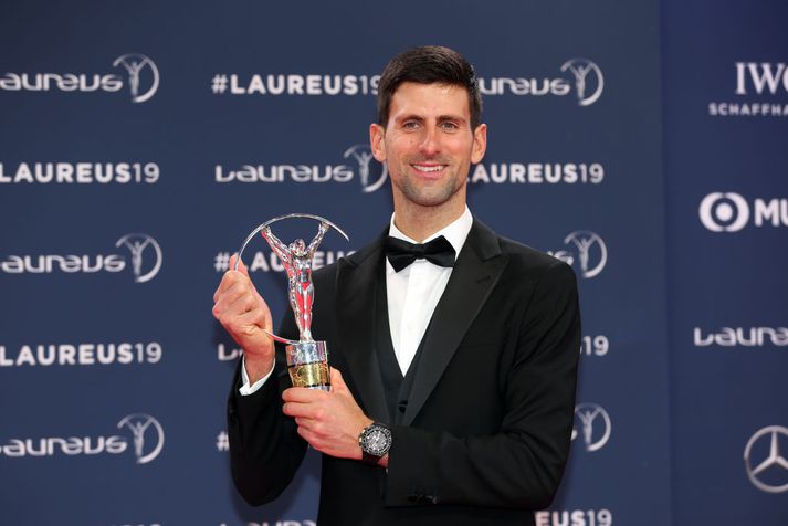 Djokovic með verðlaunin sín í gær. Biles gat ekki mætt á svæðið.