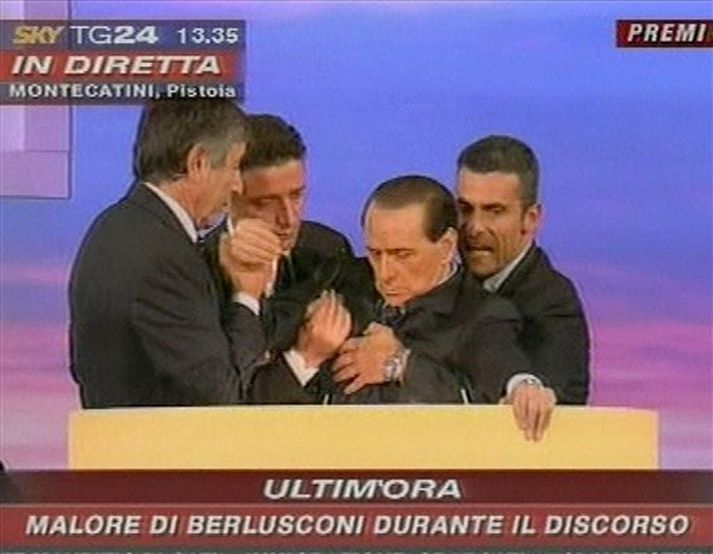 Berlusconi var borinn út af aðstoðarmönnum sínum í dag.