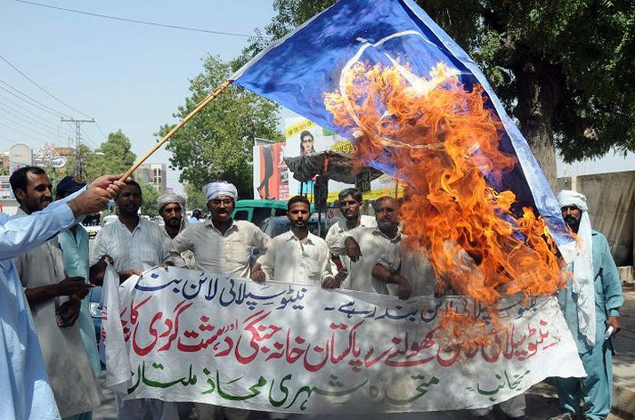 Mótmælendur í Pakistan brenna bandaríska fánann.