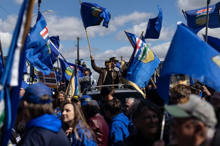 Stuðningsmenn sjálfstæðis í Alberta veifa fána fylkisins á samstöðufundi í gær þar sem undirskriftarlistinn var opinberaður.