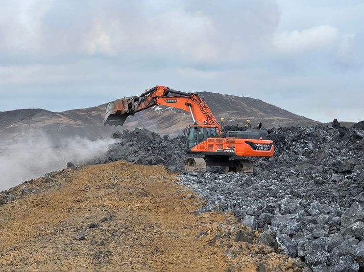 Gröfumaður notast hér við nýlegt hraun til að styrkja varnargarðinn.