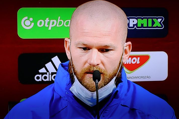 Aron Einar Gunnarsson tók niður grímuna þegar hann svaraði spurningum blaðamanna.