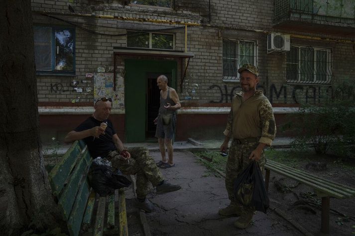 Hermenn hvíla sig fyrir framan fjölbýlishúsið sem hinn sjötugi Valerii Ilchenko býr í Kramatorsk. Hann var áður í sovéska hernum og er bálreiður út í Rússa vegna innrásarinnar þótt hann ætli ekki að verða við fyrirmælum um að flýja borgina.