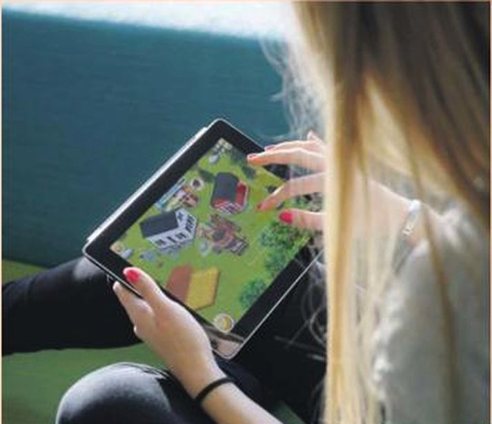 Stúlka drepur tímann í iPad-spjaldtölvu sinni með tölvuleiknum Hay Day frá Supercell. Því er spáð að fartæki og netleikir saxi hratt á hlut einkatölva og leikjatölva á næstu misserum.