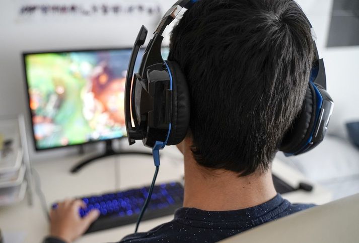 Boy with headphones playing on his computer