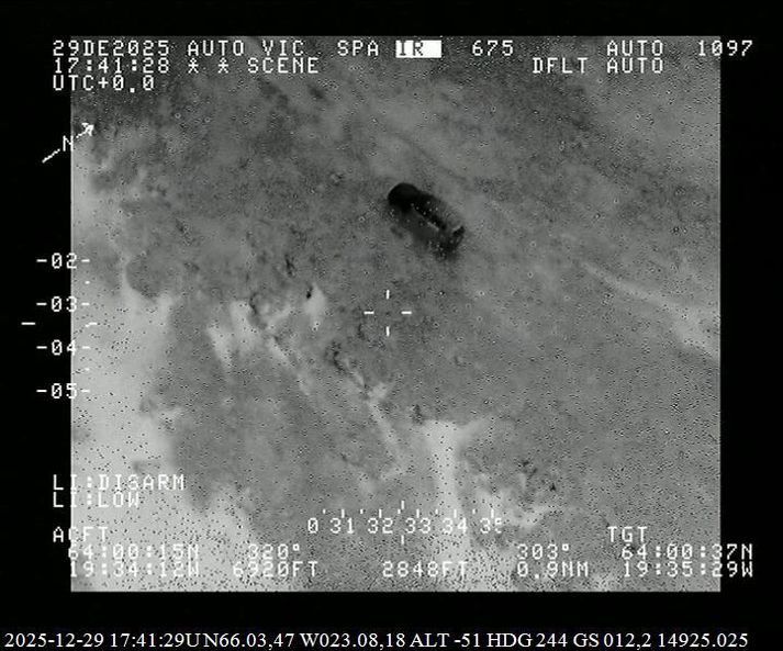 Jeppi ferðamannanna sést hér í gegnum sjónauka flugvélarinnar.