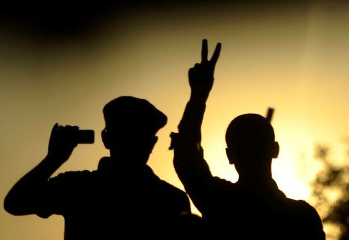 Uppreisnarmaður gerir v-merki með fingrunum, sem táknar „victory“, í fagnaðarlátunum í Tripoli.