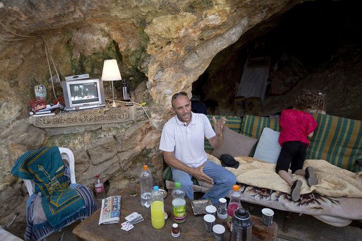 Palestínumaðurinn Khaled Zir situr þarna í helli sínum í austanverðri Jerúsalem, en þangað flutti hann ásamt fjölskyldu sinni eftir að íbúð hans var lögð í rúst af stjórnvöldum.