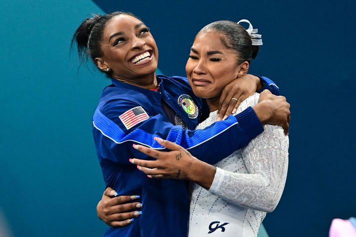 Jordan Chiles fagnar bronsinu sínu með Simone Biles eftir að úrslitunum var breytt. Sú breyting á skorinu hefur nú verið dregin til baka.