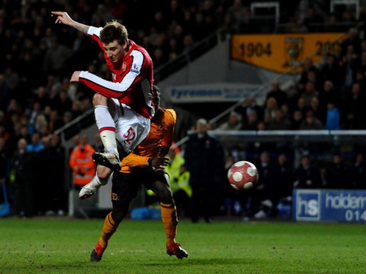 Nicklas Bendtner skorar hér sigurmark Arsenal og það má sjá Arsene Wenger, stjóra Arsenal, fylgjast með í bakgrunninum.