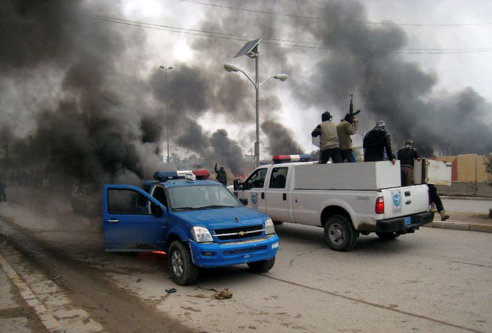 Vopnaðar sveitir íslamista keyra um götur Fallujah á lögreglubílum.