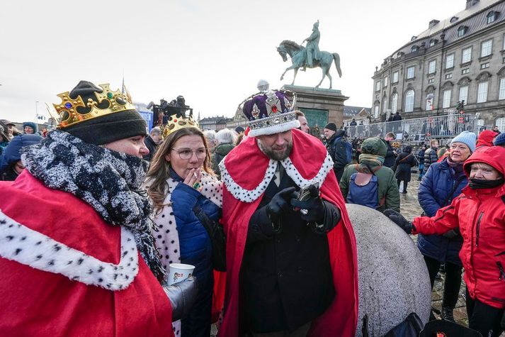 Margmenni þyrpist að hallargarði Kristjánsborgar og bíða síns nýja konungs með eftirvæntingu og margir í skrautlegum búningum.