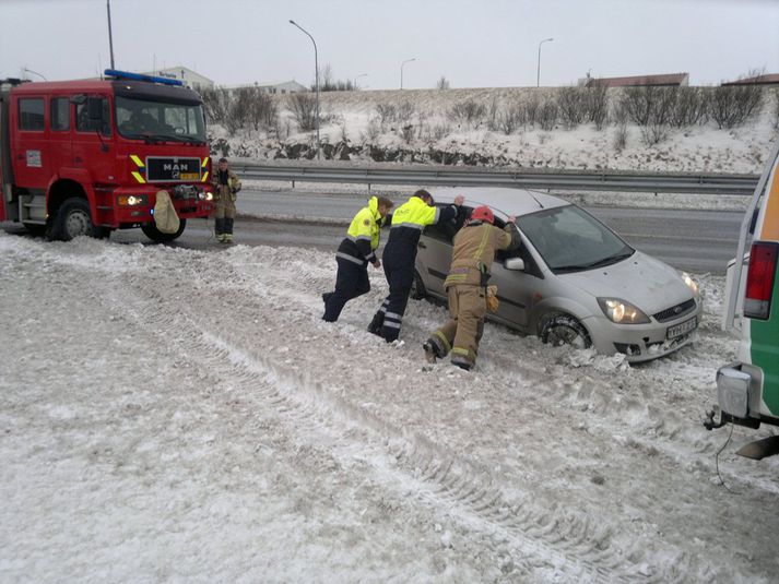 Bíllinn dreginn upp úr snjóskafli. 