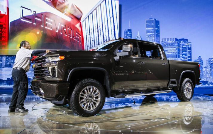 Starfsmaður á bílasýningu dustar af Chevrolet Silverado. Á myndinni sést vel hvernig framendi bílsins nær starfsmanninum vel upp á bringu.