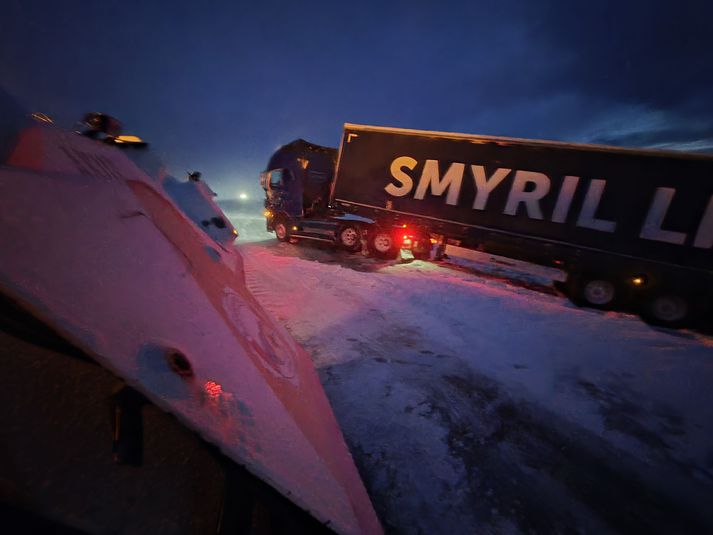 Ökumaður eins vörubíls lenti í vandræðum undir Hafnarfjalli og þurfti einnig að ferja farþega úr rútu og strætisvagni.