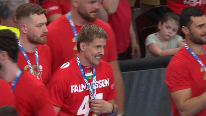 Bjarki Már passar vel upp á medalíuna fyrir Aron.