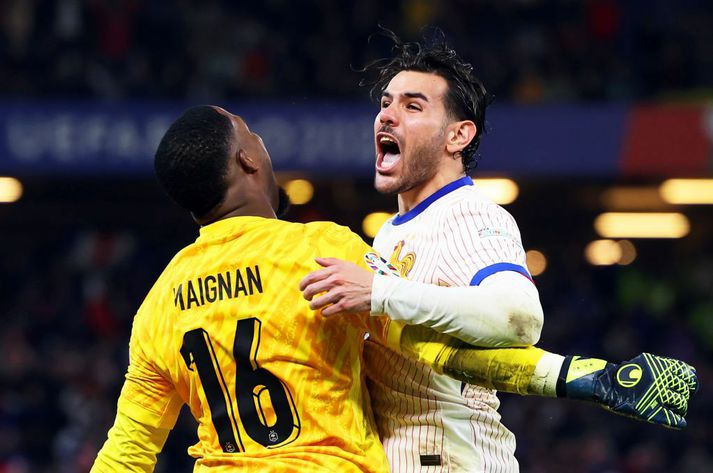 Mike Maignan og Theo Hernandez fagna eftir sigurinn í vítaspyrnukeppninni í kvöld.