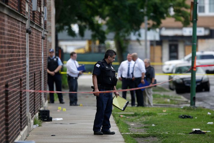 Lögreglumenn á vettvangi einnar af fjölmörgum skotárásum undanfarinnar helgar. Yfirvöld í Chicago reyna að kljást við morðölduna en illa gengur. Lögreglu tekst aðeins að leysa lítið brot morðmála.