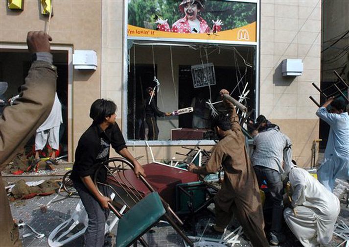 Mótmælendur láta ófriðlega fyrir utan McDonalds-veitingastað í Lahore í Pakistan í gær.