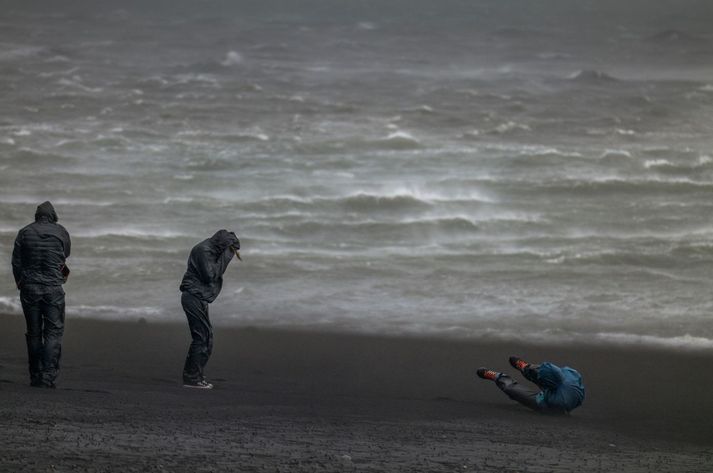 Ferðamennirnir í Reynisfjöru höfðu gaman að náttúruöflunum í fyrstu en gamanið kárnaði fljótt þegar kom að því að ganga aftur á bílastæðið. Fólk fauk í mestu hviðunum.