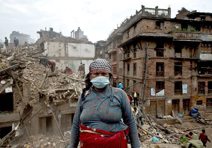 Kona í Bhaktapur leitar að eigum sínum innan um rústirnar.