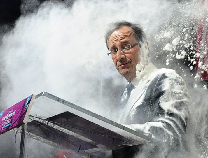 Hollande var augljóslega ekki skemmt en hann hélt þó ró sinni og lauk ræðunni þakinn hvíta duftinu.