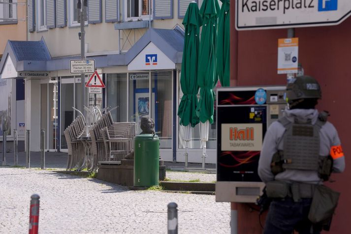 Lögregluþjónar sitja um bankann, þar sem ótilgreindur fjöldi ræningja heldur fólki í gíslingu.