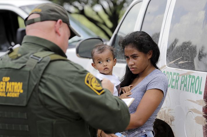 Móðir frá Hondúras ræðir við landamæravörð eftir að hún reyndi að komast ólöglega yfir landamærin frá Mexíkó í Texas.