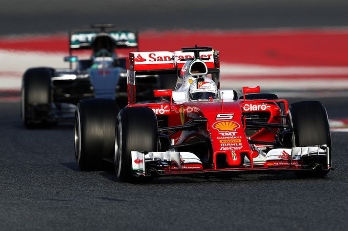 Vettel í forgrunni á Ferrari bílnum og Rosberg í bakgrunni á Mercedes bílnum.