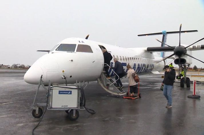 Farþegar á leið til Akureyrar ganga um borð í Dash 8 Q400-vél Icelandair á Reykjavíkurflugvelli.