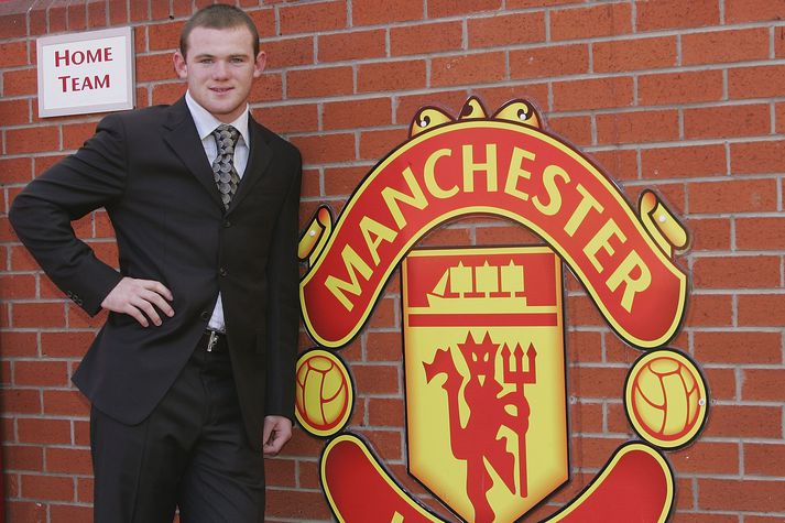 Wayne Rooney stillir sér upp við merki Mancester United á Old Trafford eftir að hann var kynntur sem nýr leikmaður félagsins.