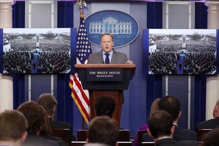 Sean Spicer, fjölmiðlafulltrúi Hvíta hússins á blaðamannafundi með myndum af mannfjöldanum á innsetningarathöfninni.