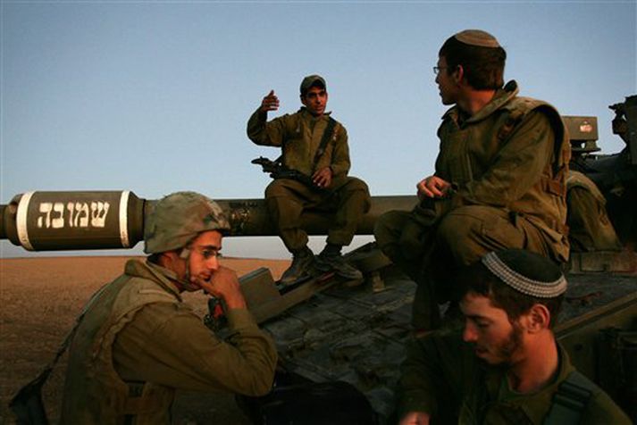 Ísraelskir hermenn spjalla saman við Gaza-ströndina í gær.