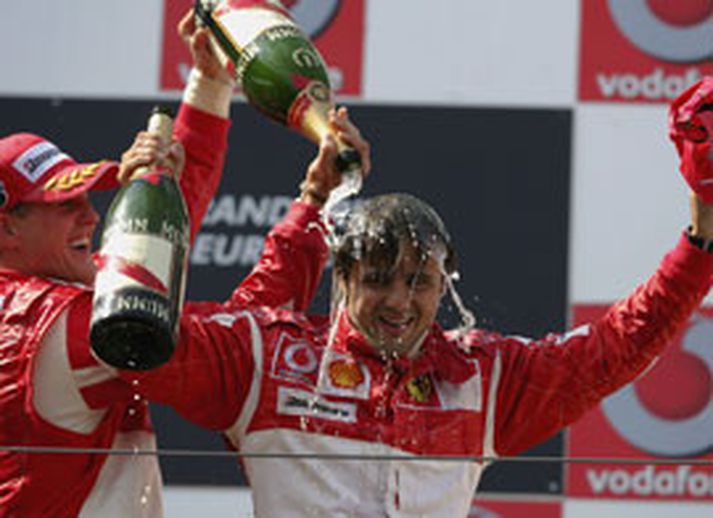 Michael Schumacher (t.v.) hellir hér kampavíni yfir félaga sinn hjá Ferrari, Felipe Massa á brautinni í Nürburgring í dag en sá síðarnefndi var að stíga á verðalaunapall í fyrsta sinn í Formúlu 1.