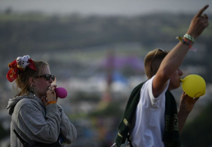 Gestir á Glastonbury-tónlistarhátðinni anda að sér hlátursgasi úr blöðrum árið 2019. Neysla gassins verður bönnuð í Bretlandi frá og með áramótum.