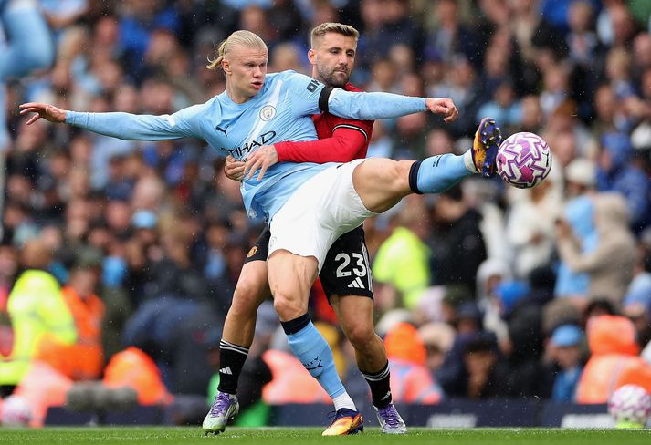 Luke Shaw reynir að hafa hemil á Erling Haaland.