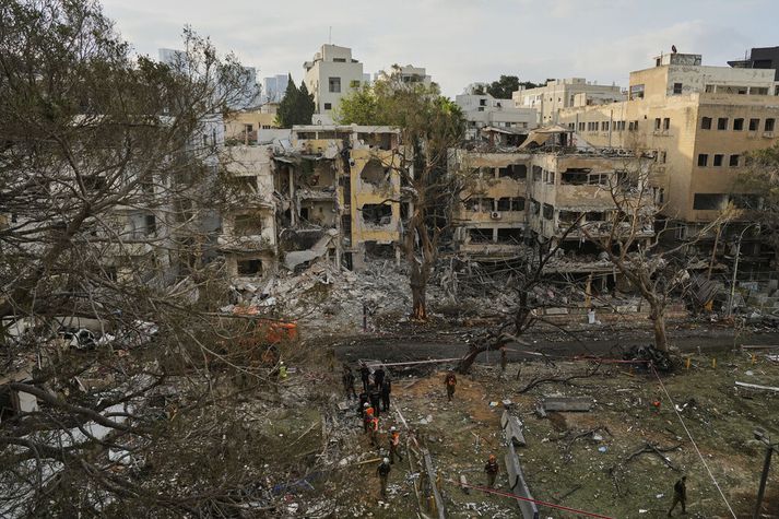 Tjónið er víða mikið í Ísrael eins og sjá má á þessum löskuðu byggingum í Tel Aviv þar sem björgunasveitir eru að störfum.