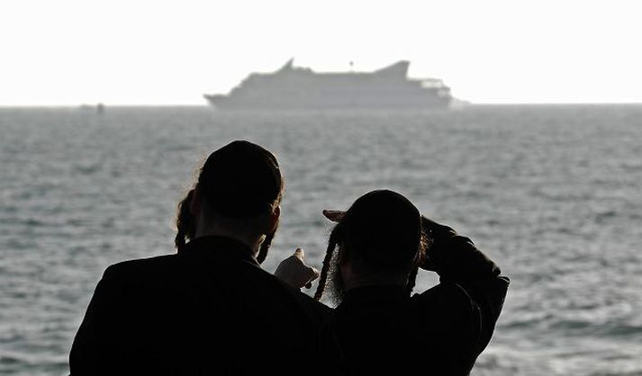 Tveir rétttrúaðir gyðingar horfa á tyrkneska skipið Mavi Marmara, sem Ísraelar réðust á á mánudag. Nordicphotos/AFP