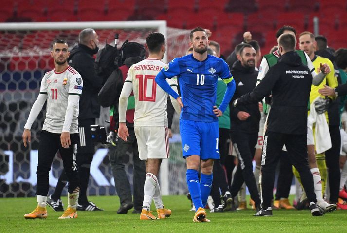 Gylfi Þór Sigurðsson sársvekktur í leikslok á meðan Ungverjar fagna.